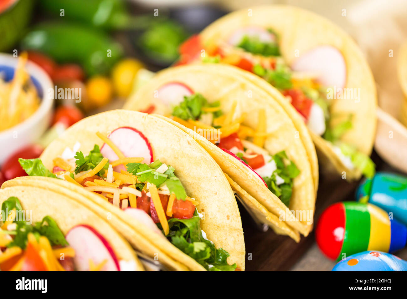 Ground beef tacos with romaine lettuce, diced tomatoes, radished, and