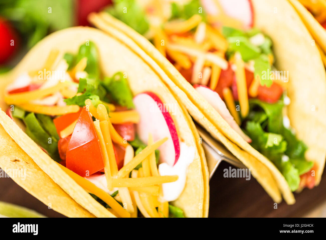 Ground beef tacos with romaine lettuce, diced tomatoes, radished, and
