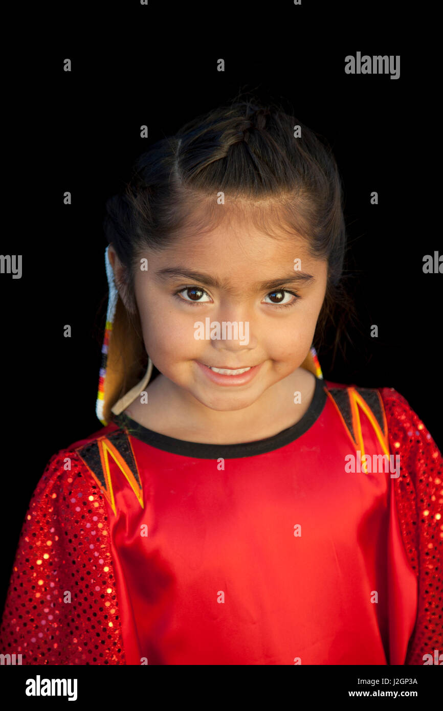 Young girl and pow wow dancer, Lyric Dixey (Shoshone-Bannock), smiles as she shows off her pretty red dress during the Fort Hall Indian Festival. Stock Photo