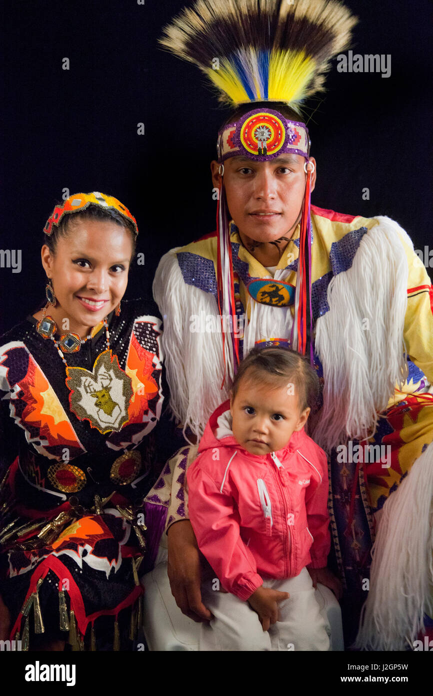 Family of three: Mother Elishia Lahr (Navajo) jingle dress, father Neil Lahr grass dancer (Blackfoot) and daughter Harmony Lahr. Stock Photo