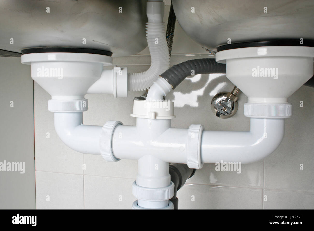 Drain pipes under a kitchen sink with dishwasher connection Stock Photo -  Alamy