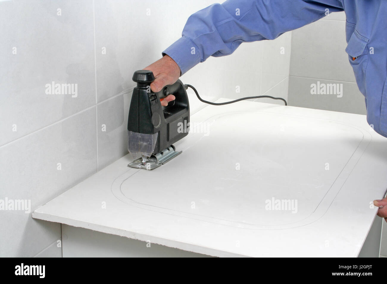 Workman using an electric keyhole saw tor the installation of a sink Stock Photo Alamy