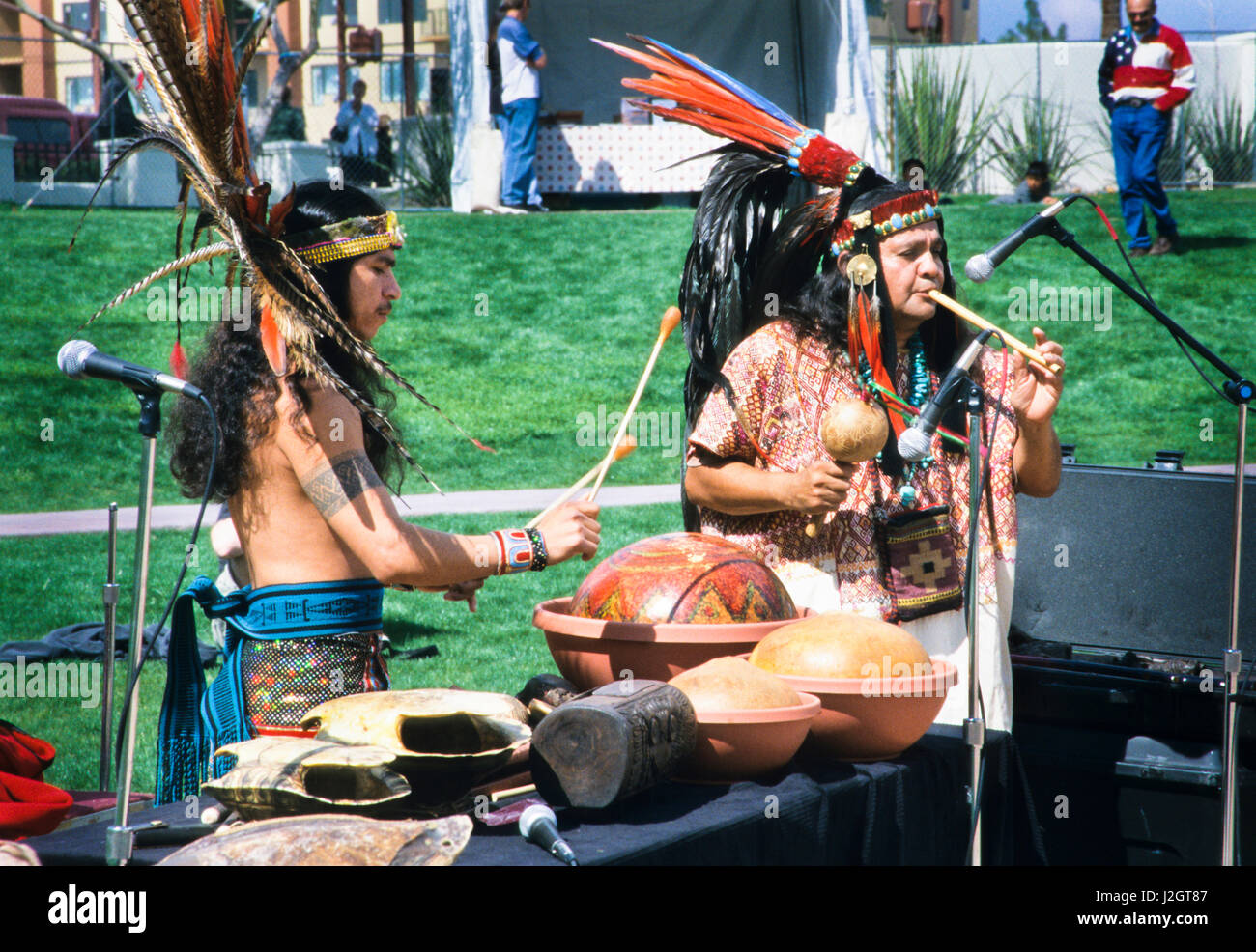 Two Aztec men demonstrate traditional musical instruments such as the wooden whistle, gourd rattles and a variety of drums Stock Photo