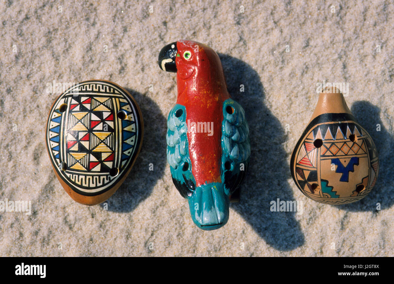 Aztec arts and crafts of a painted clay whistle flute of a colorful parrot bird, Mexico. Stock Photo