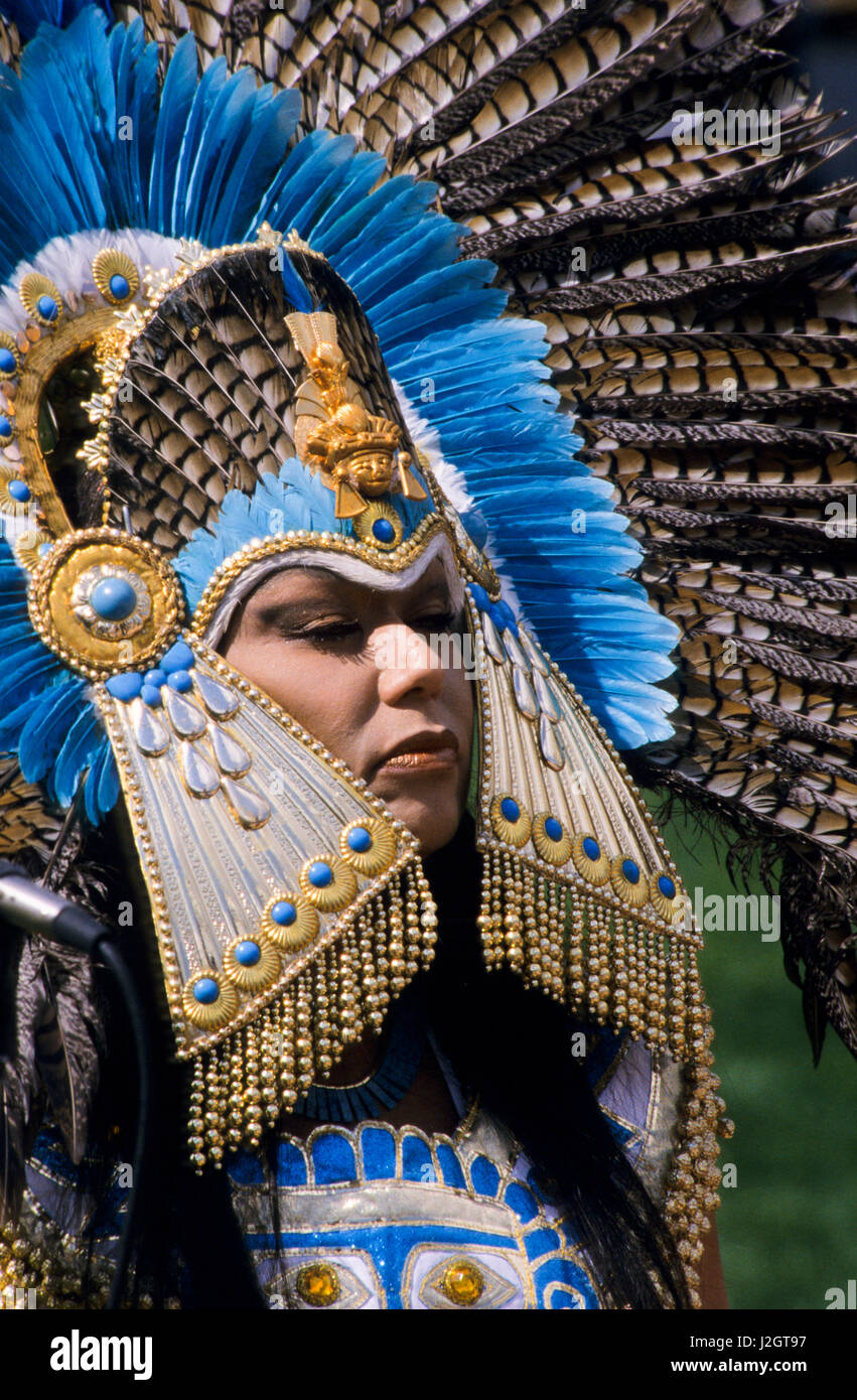 Aztec woman wears a magnificent traditional golden headdress made with blue stones and blue exotic bird feathers Stock Photo