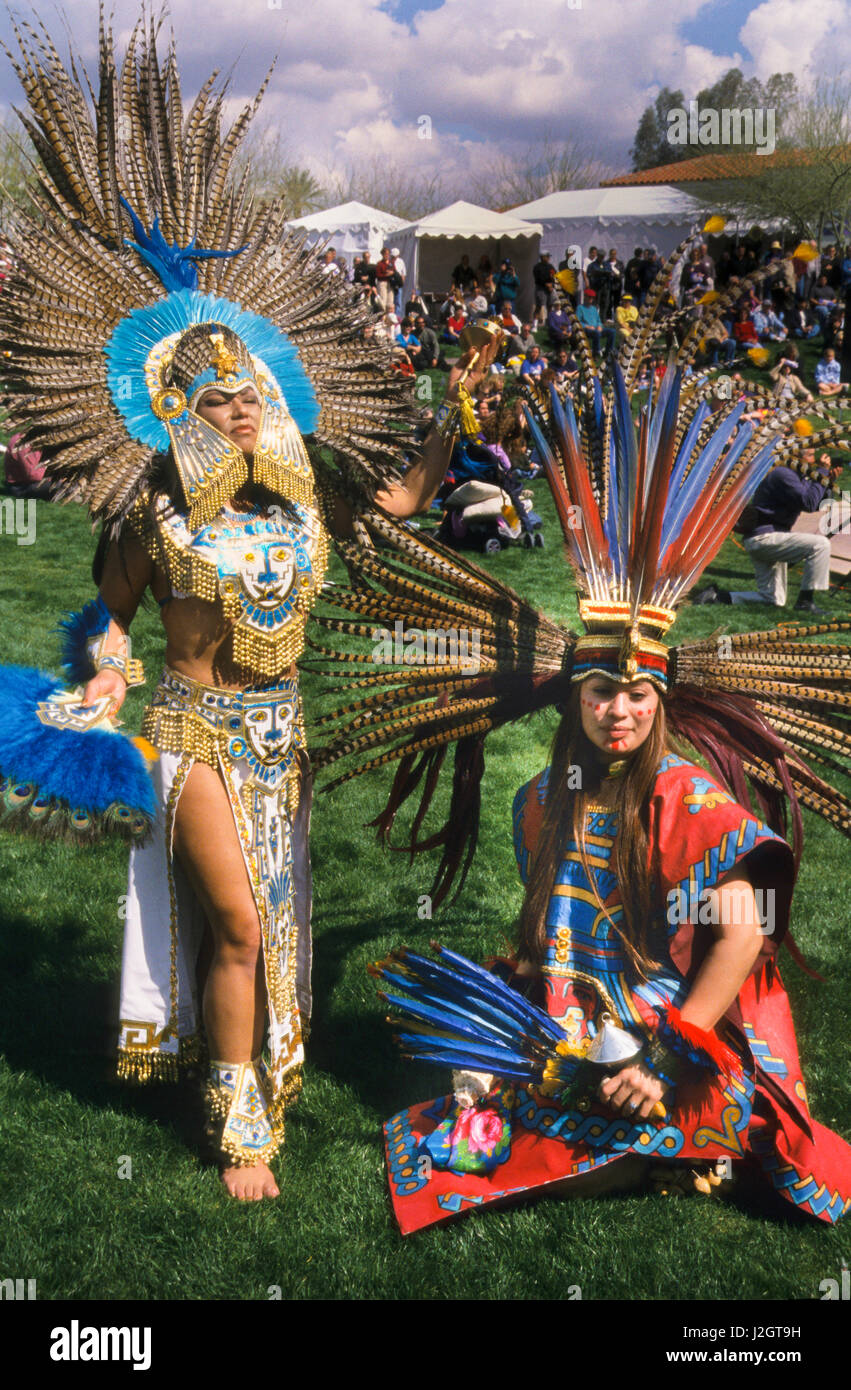 Two Aztec women dressed in magnificent traditional Aztec regalia and headdresses pose during a ceremonial dance presentation at the Heard Museum in Phoenix Arizona Stock Photo