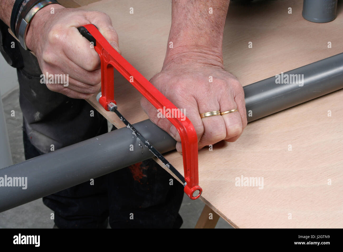 Handyman cutting pvc drain pipe with a saw Stock Photo Alamy