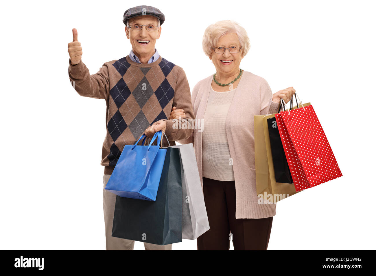 Elderly man and woman with shopping bags making a thumb up gesture isolated on white background Stock Photo