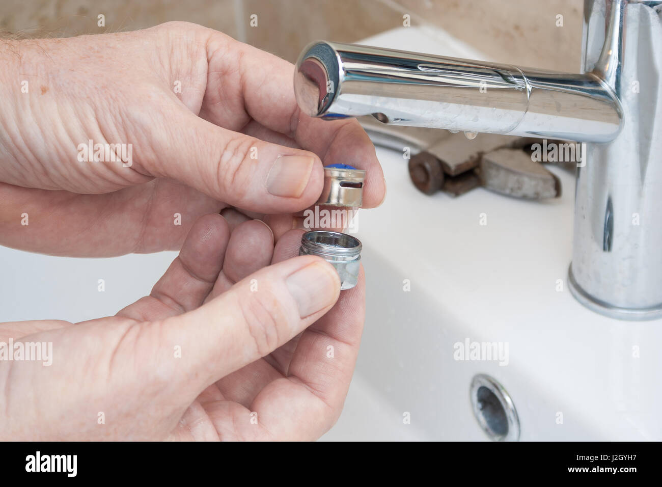 Plumber repairing a faucet in a bathroom Stock Photo Alamy