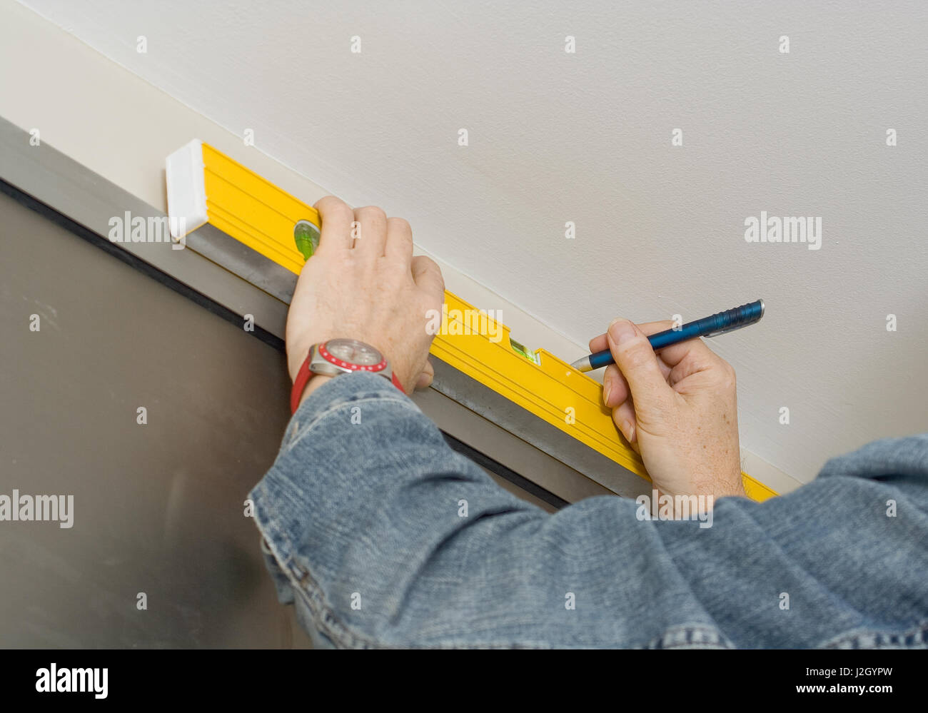 Handyman marking drill holes with a spirit level Stock Photo