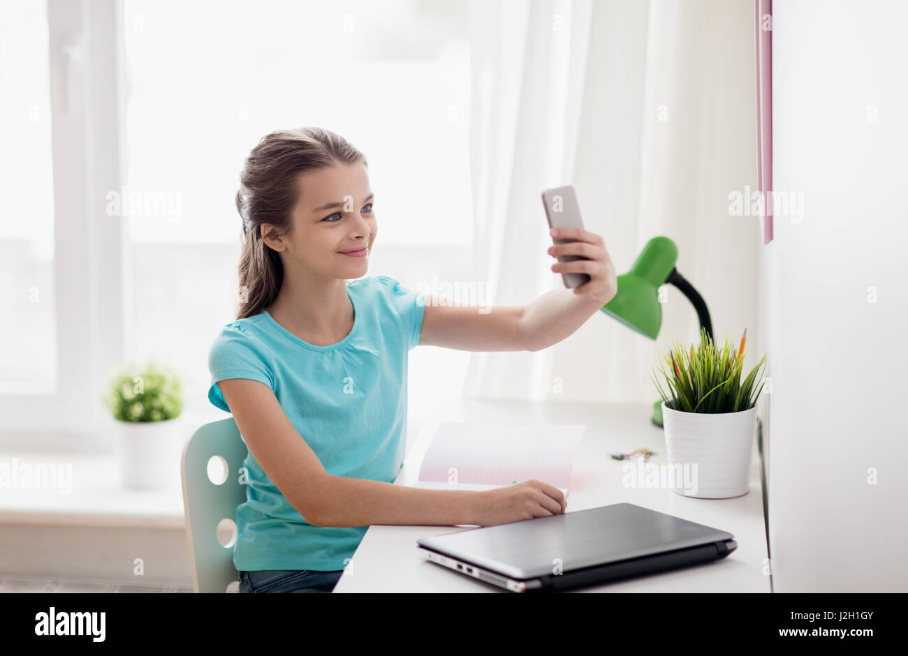 happy girl with smartphone taking selfie at home Stock Photo - Alamy