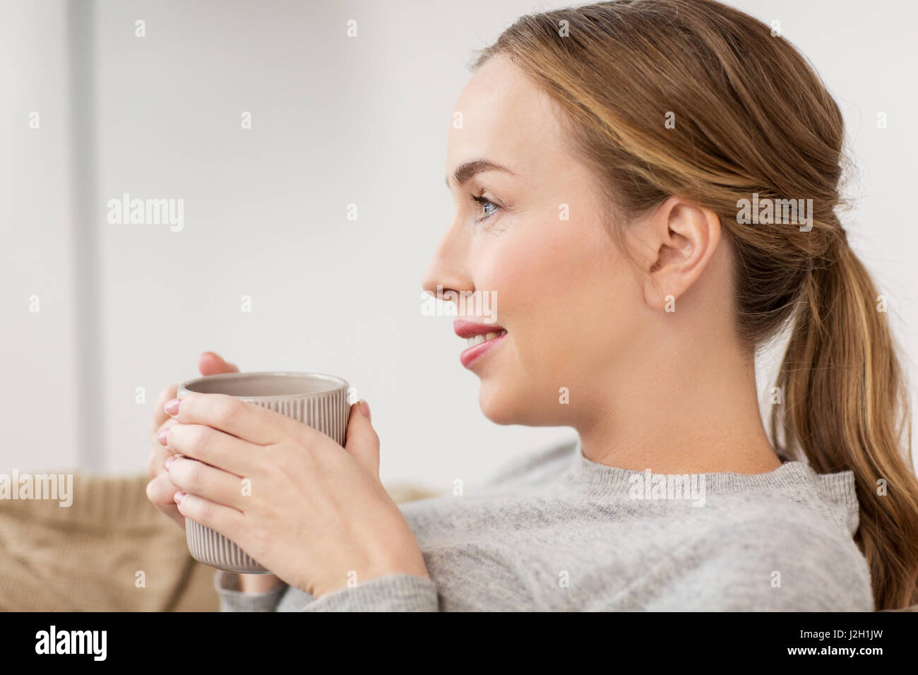 happy woman with cup or mug drinking at home Stock Photo