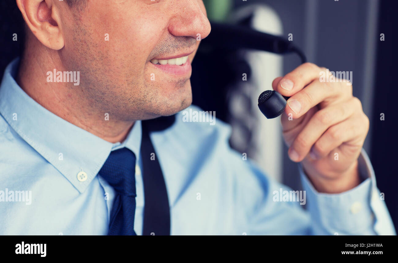 close up of happy bus driver talking to microphone Stock Photo