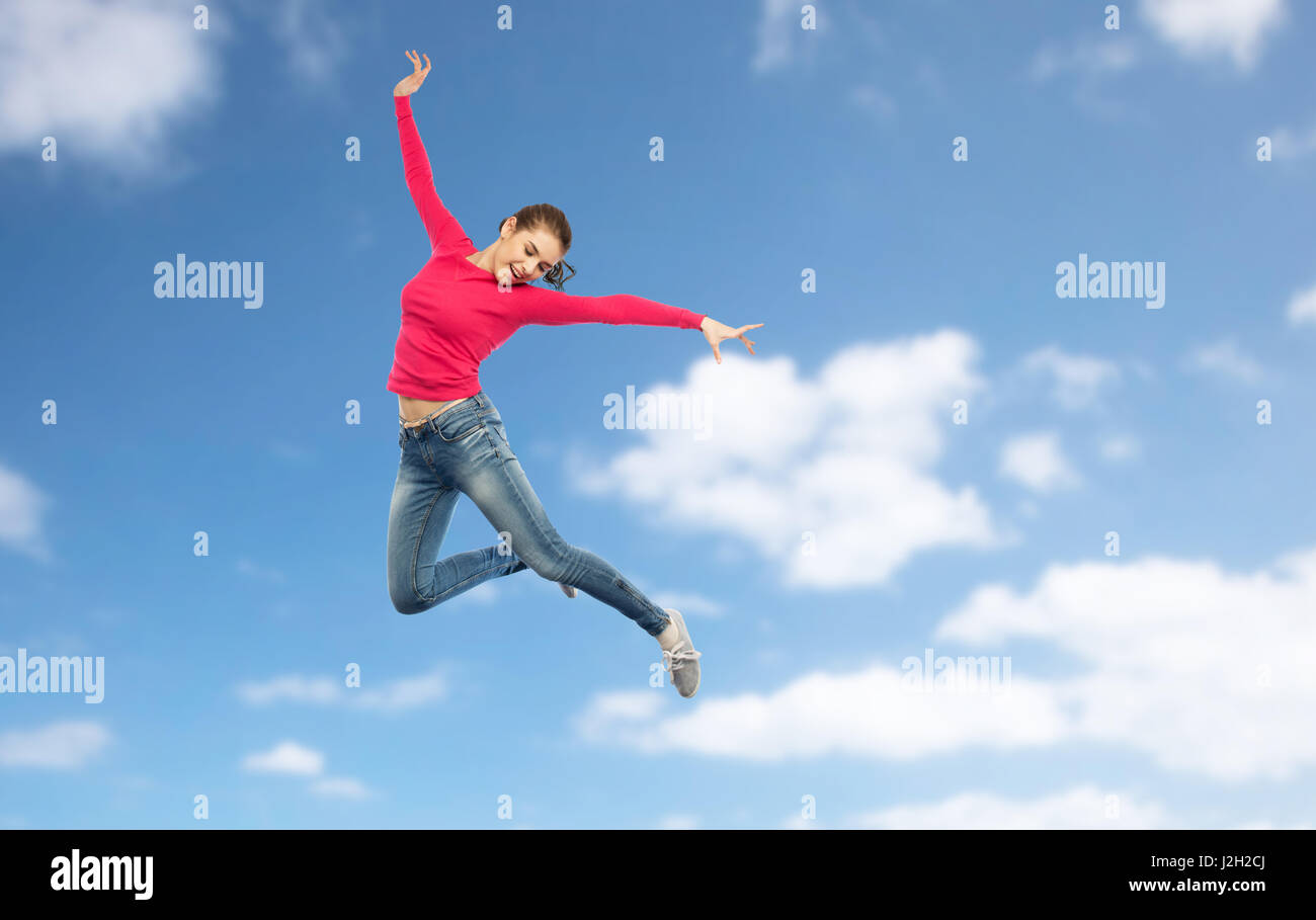 happy young woman jumping in air or dancing Stock Photo - Alamy