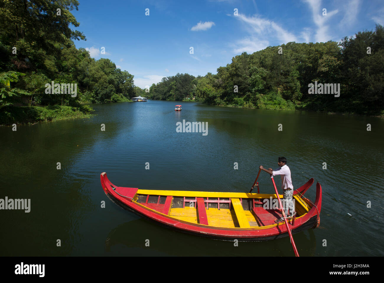 A boatman steering wooden boat at the Foy's Lake Amusement World. It is a theme park. It was dug in 1924. Chittagong, Bangladesh. Stock Photo