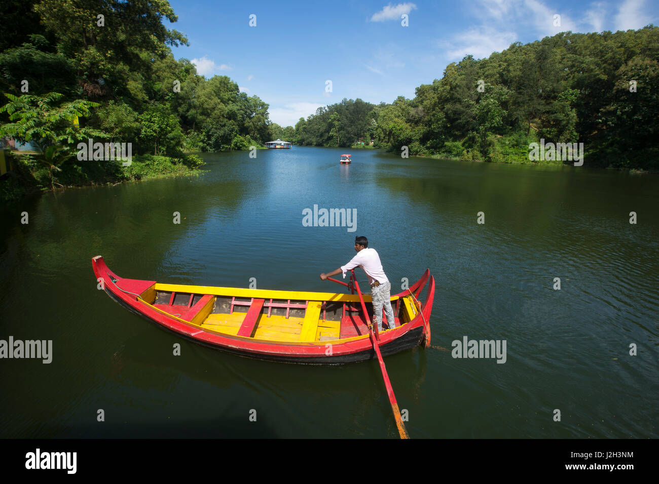 A boatman steering wooden boat at the Foy's Lake Amusement World. It is a theme park. It was dug in 1924. Chittagong, Bangladesh. Stock Photo