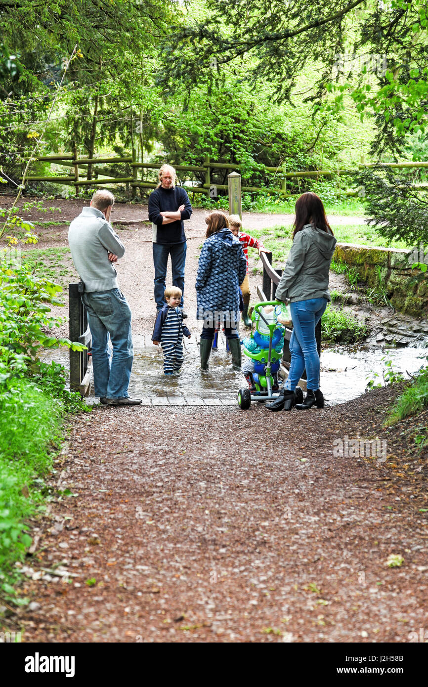 A young family playing in a stream at The Wolseley Centre, Staffordshire Wildlife Trust’s HQ at  Wolseley Bridge, Rugeley, Staffordshire, England, UK Stock Photo