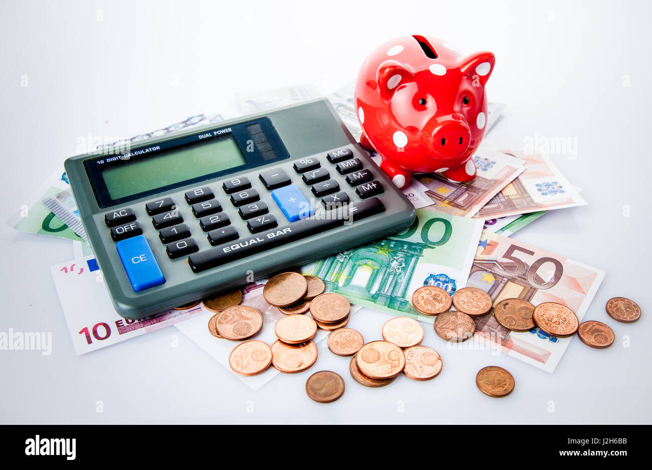 Red piggy bank with calculator and money Stock Photo - Alamy