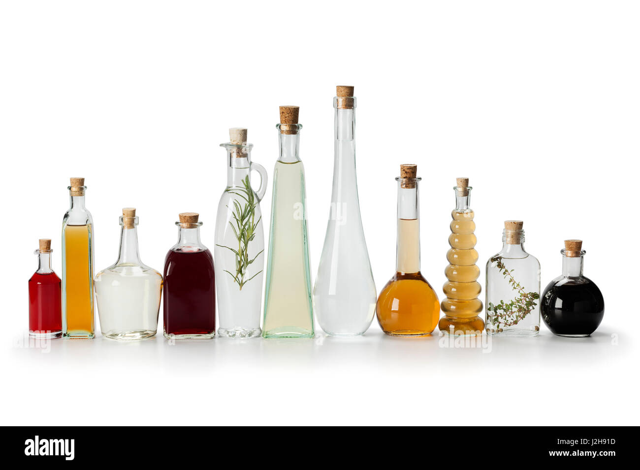 Row of bottles with homemade organic vinegar on white background Stock Photo