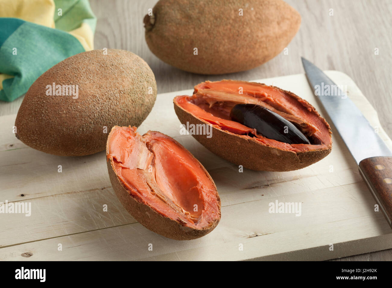 Fresh ripe sapodilla cut in two parts on a cutting board Stock Photo - Alamy