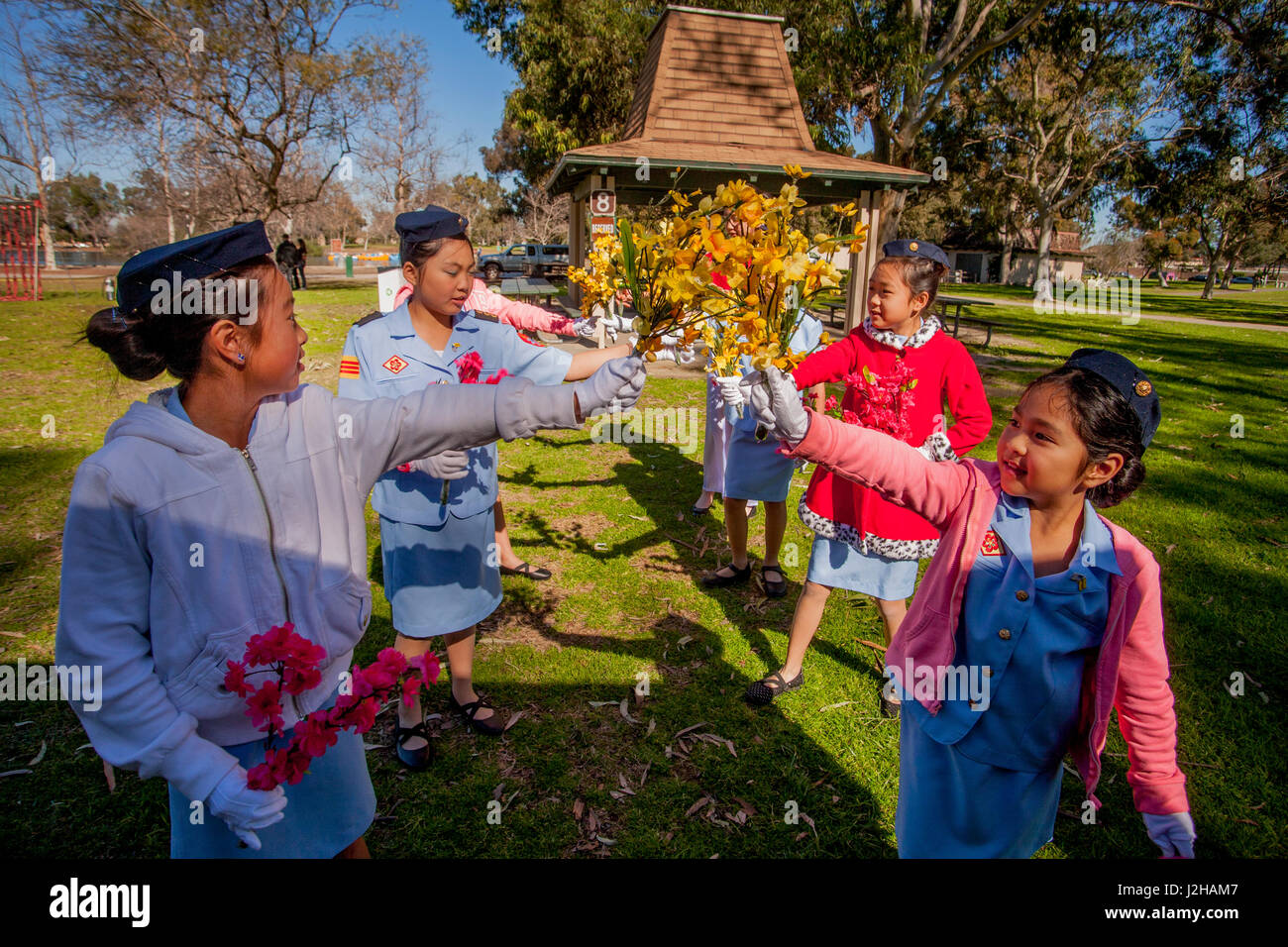 Vietnamese American girls in Ao Dai costumes dance to celebrate the Lunar New Year or Tet in a Fountain Valley, CA, park. Stock Photo