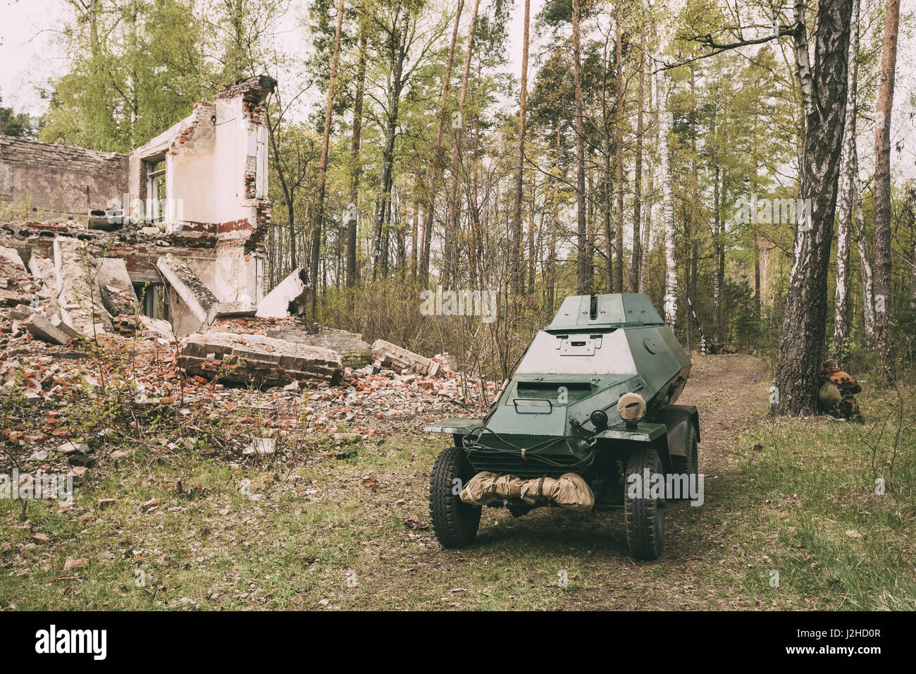 Russian Armoured Soviet Scout Car BA-64 Of World War II Near Ruined Building In Spring Forest. Vehicle Of Red Army Stock Photo