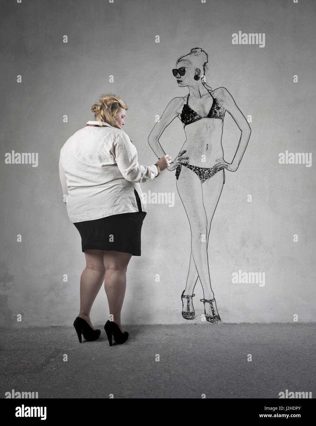 Fat woman drawing her ideal skinny figure Stock Photo