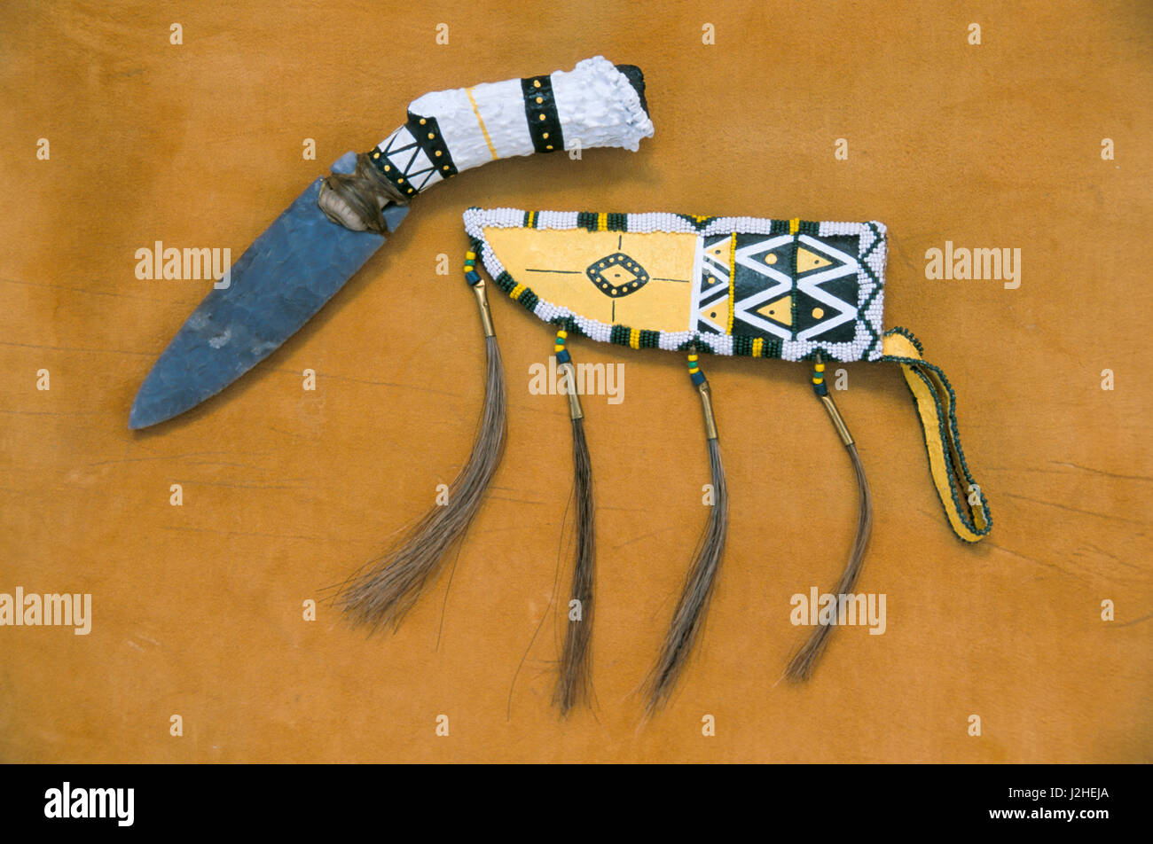 Decorated with paint and beadwork is a contemporary Blackfeet leather sheath with horsehair and a stone knife with a buck horn handle (PR) Stock Photo