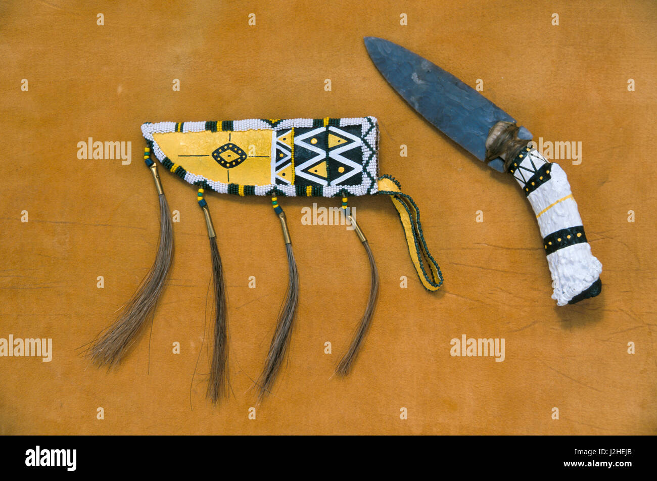 Decorated with paint and beadwork is a contemporary Blackfeet leather sheath with horsehair and a stone knife with a buck horn handle (PR) Stock Photo