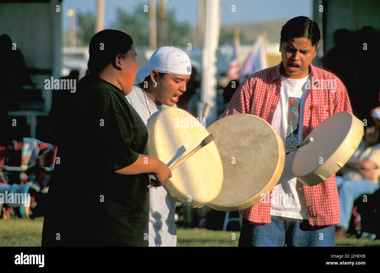 Group of Native American teenage boys play drums and sing traditional