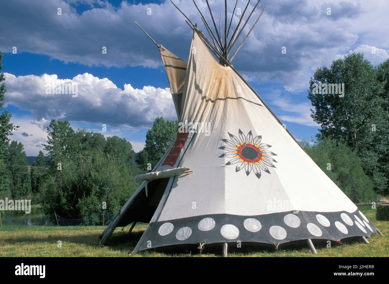 Painted and decorated Blackfeet tepee with the Blackfeet circular symbol and painted dots on the bottom border Stock Photo