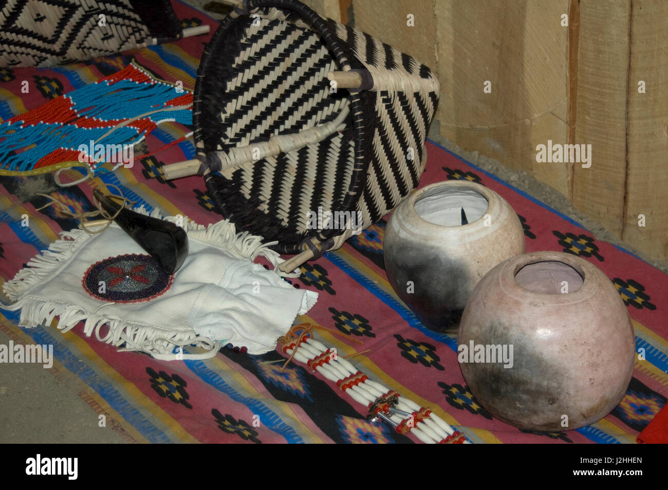 Display of Mandan craft items such as local clay pottery jars, willow gathering basket and brain-tanned leather bag Stock Photo