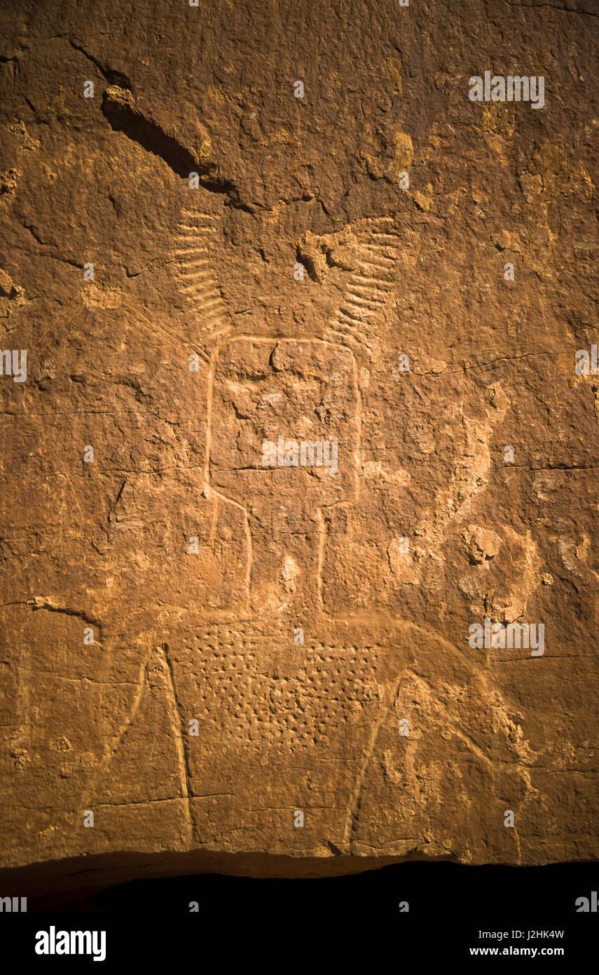 Ancient Ute petroglyph symbols of a human figure of a medicine man carved onto cliff walls, Vernal Utah Stock Photo