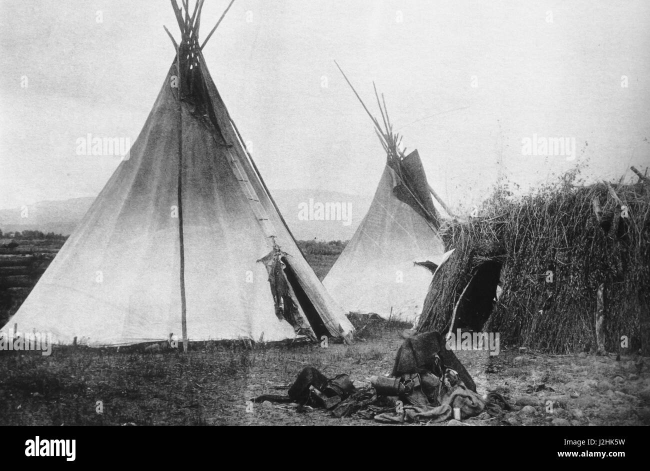 Historic photo, late 1880's, of a Utes Indian encampment of tipis and a willow wickiup shelter Stock Photo