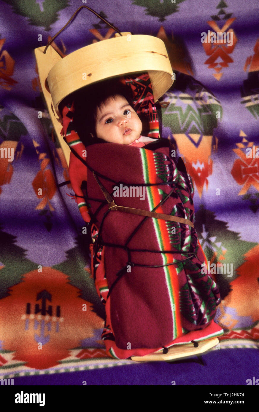Native American baby laced up onto a traditional Navajo wooden cradleboard (MR) Stock Photo