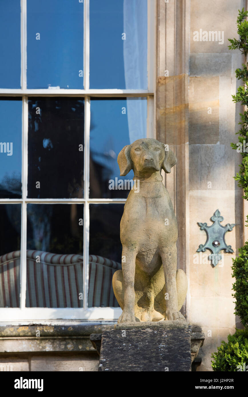 Stone dog statue outside a cotswolds stone house. Chipping Campden, Gloucestershire, England Stock Photo