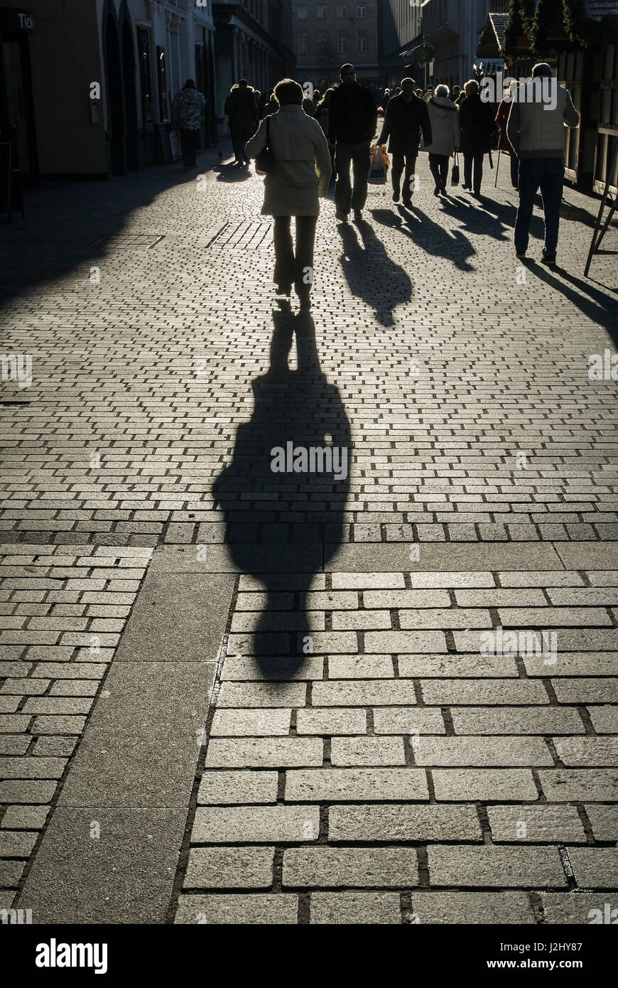 Shadow of person on cobbles Stock Photo