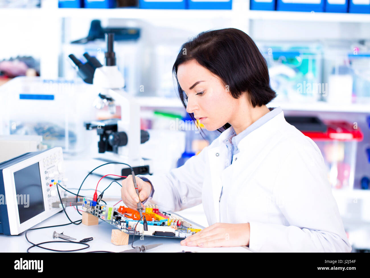 Female engineer soldering a circuit board. Stock Photo