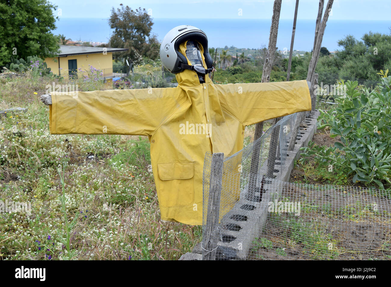 Extravagant scarecrow realized with a helmet and raincoat Stock Photo