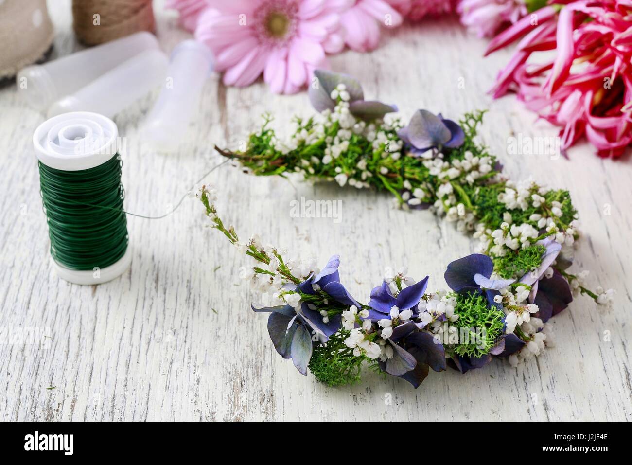 Florist at work: how to make door wreath with white erica plant and hortensia flower. Stock Photo