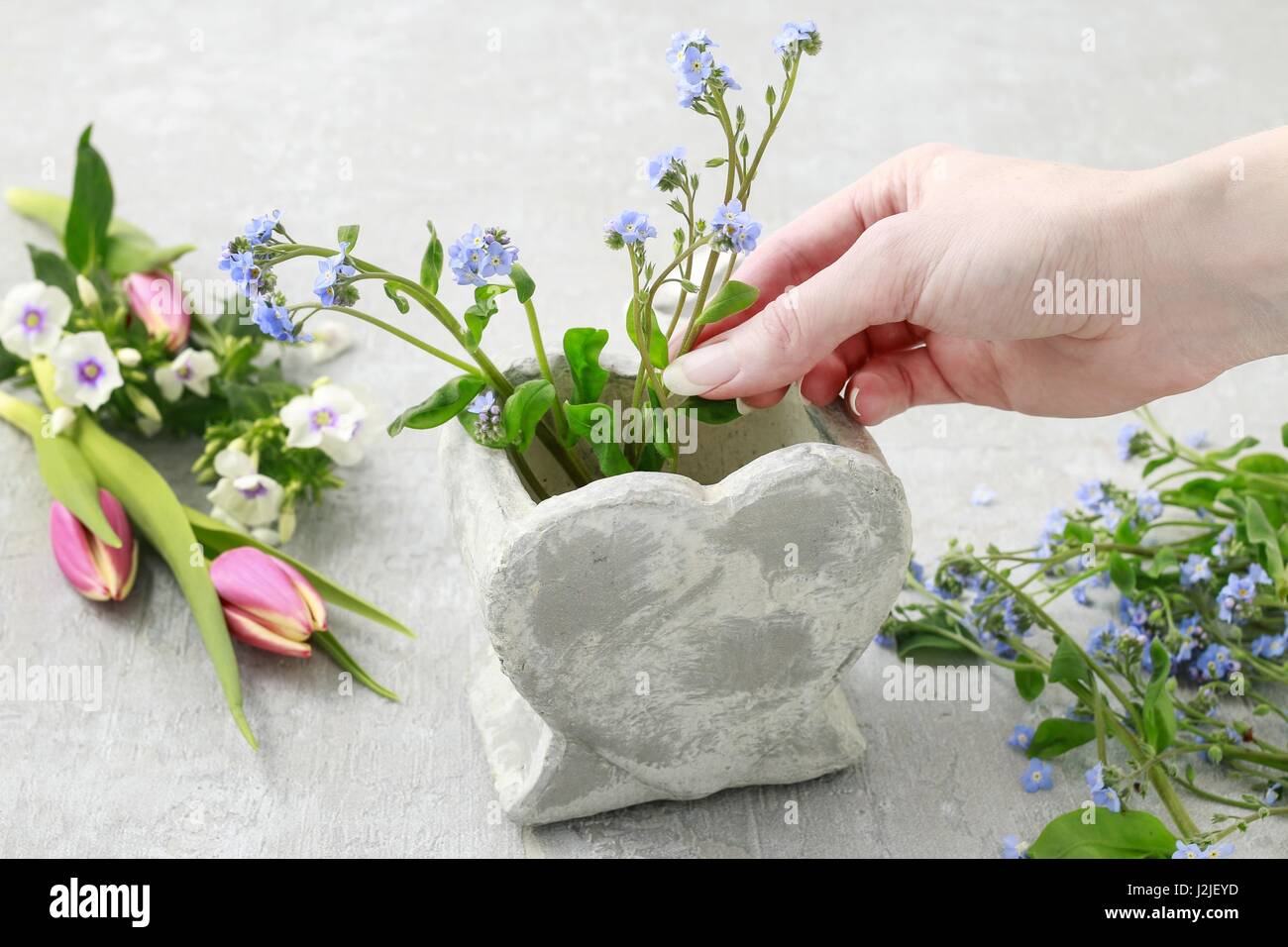 Florist at work How to make floral arrangement inside stone heart vase