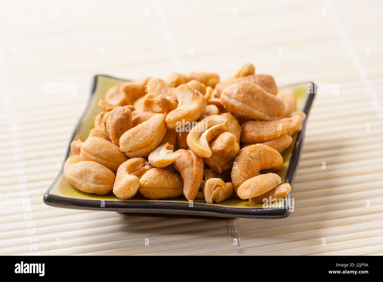 Closeup of a small plate with toasted salted cashew nuts. Stock Photo