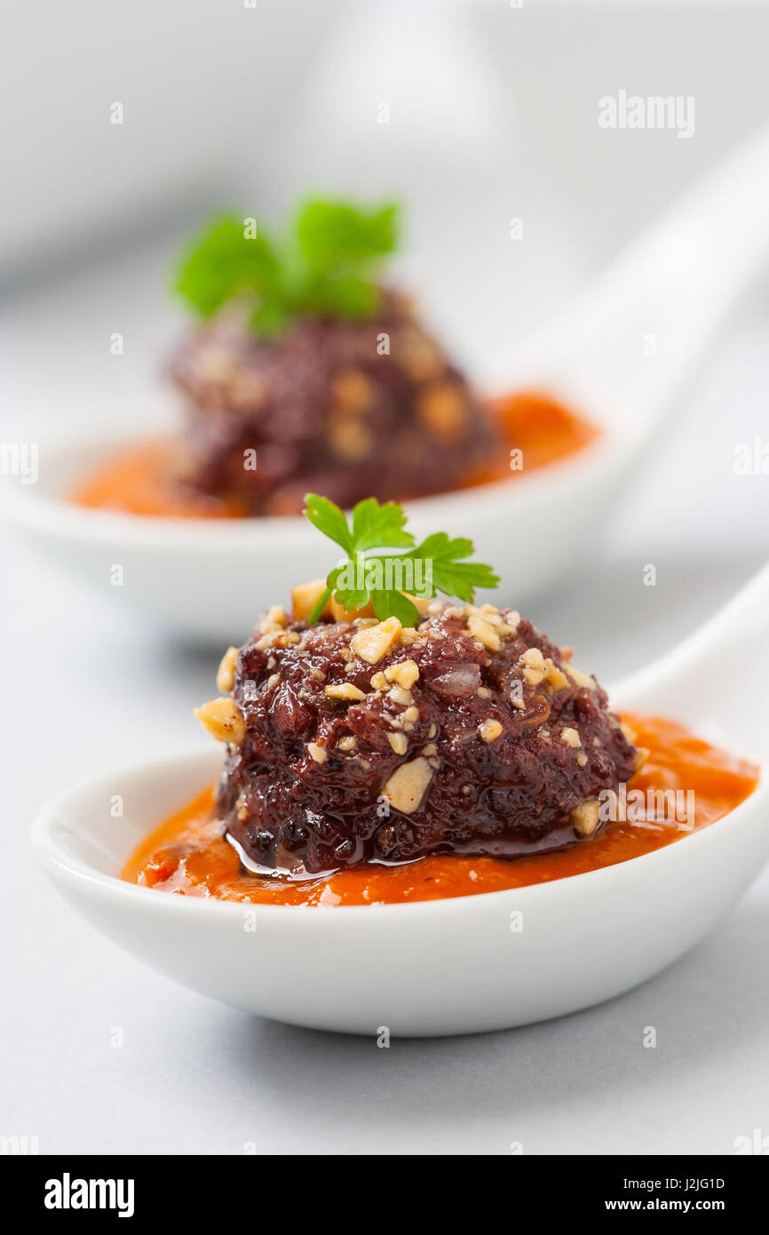 Blood and rice sausage served on a white plate with tomato sauce as ...