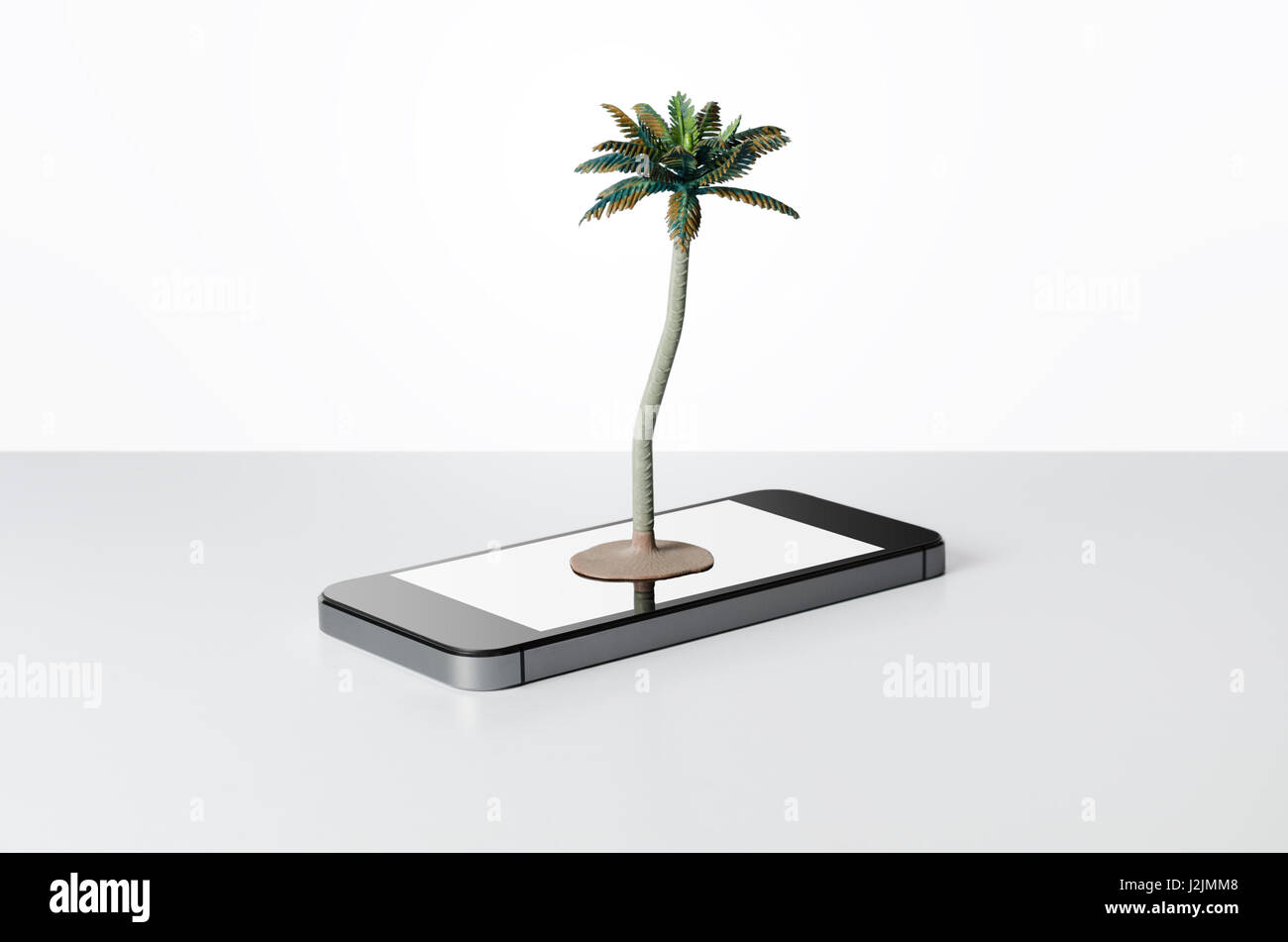 Toy palm tree on a smart phone Stock Photo