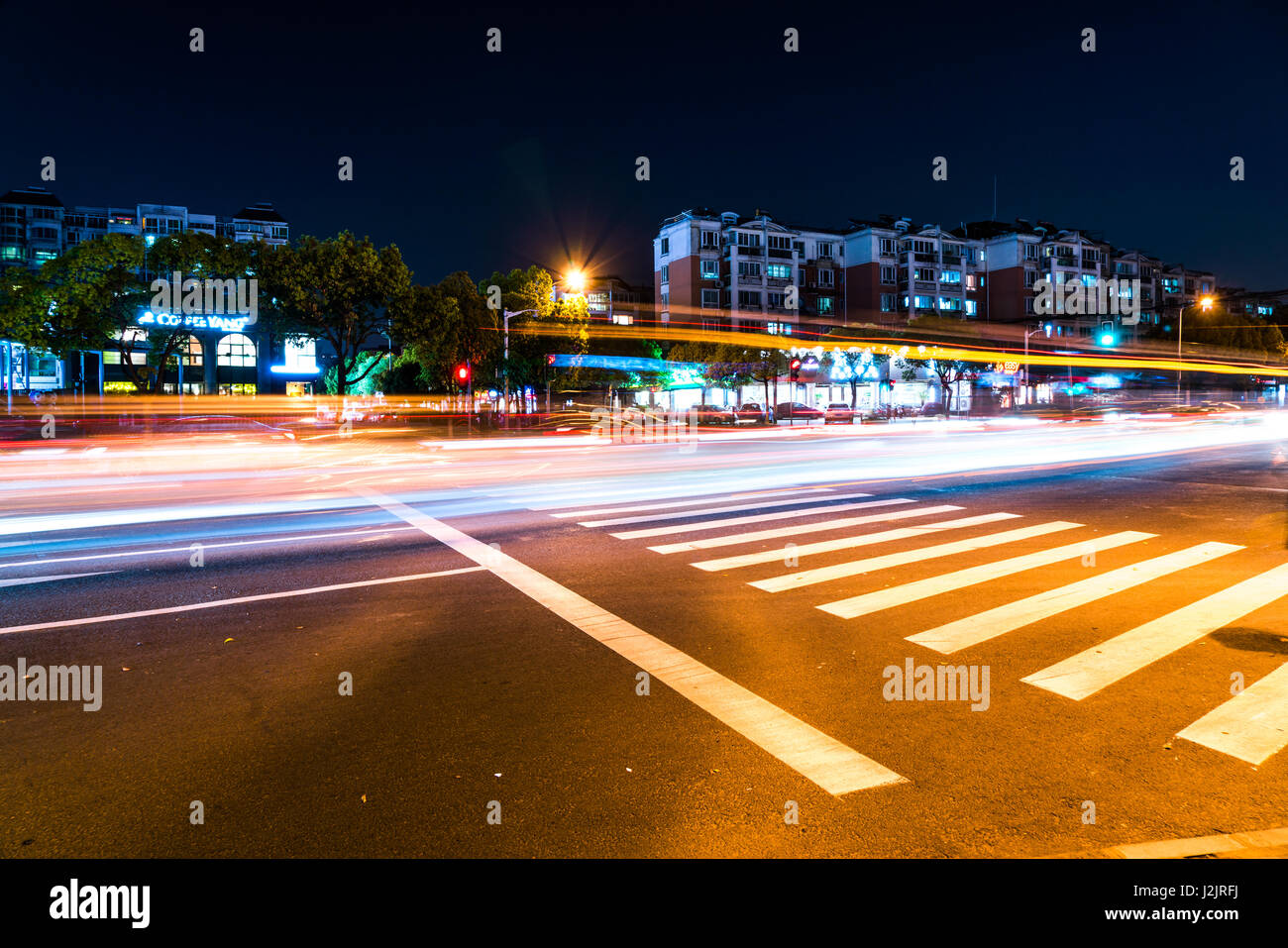 Fast moving traffic with the red and golden light on the crosswalk road Stock Photo