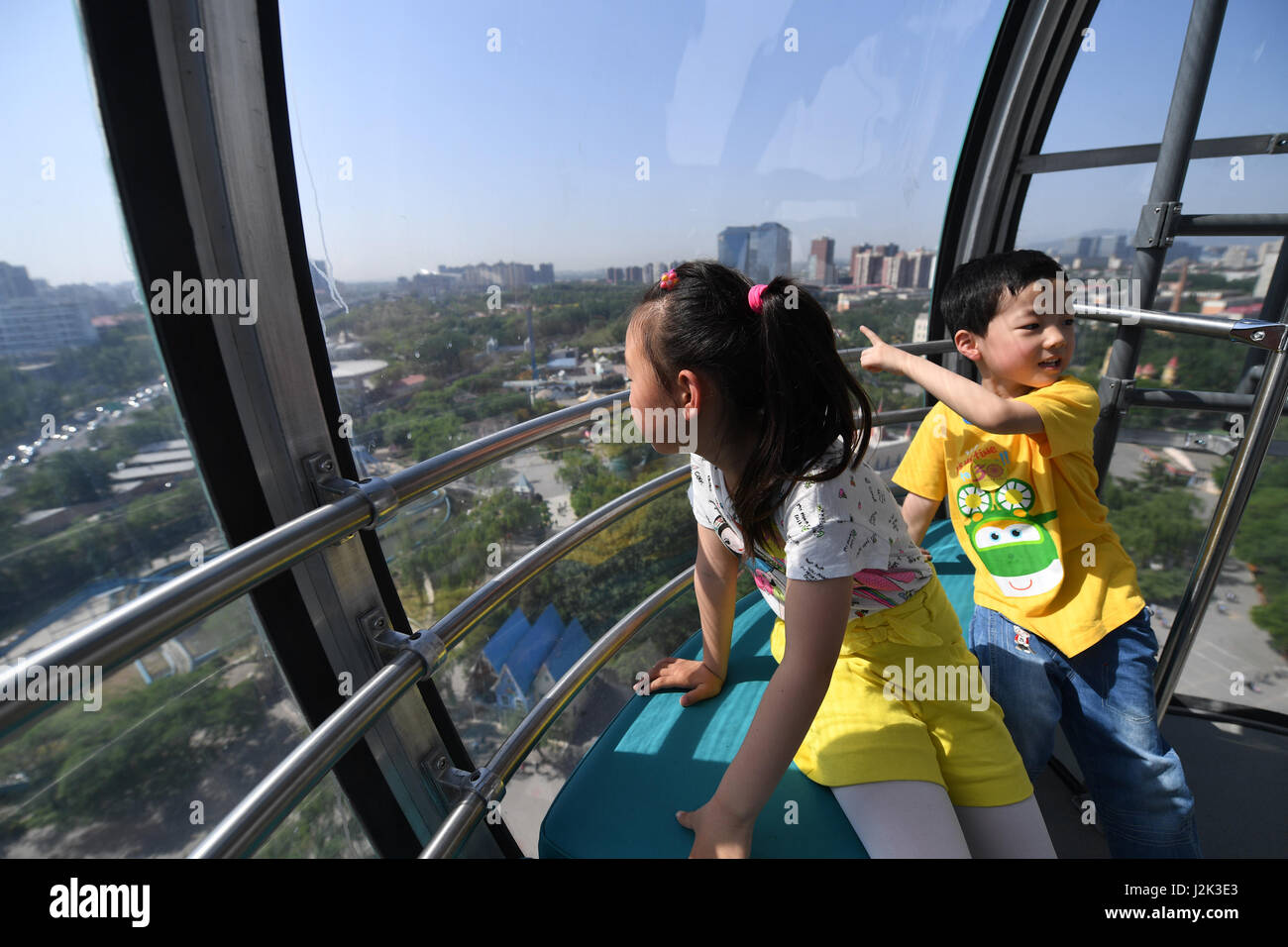 Beijing, China. 29th Apr, 2017. Two kids take a new ferris wheel at the ...