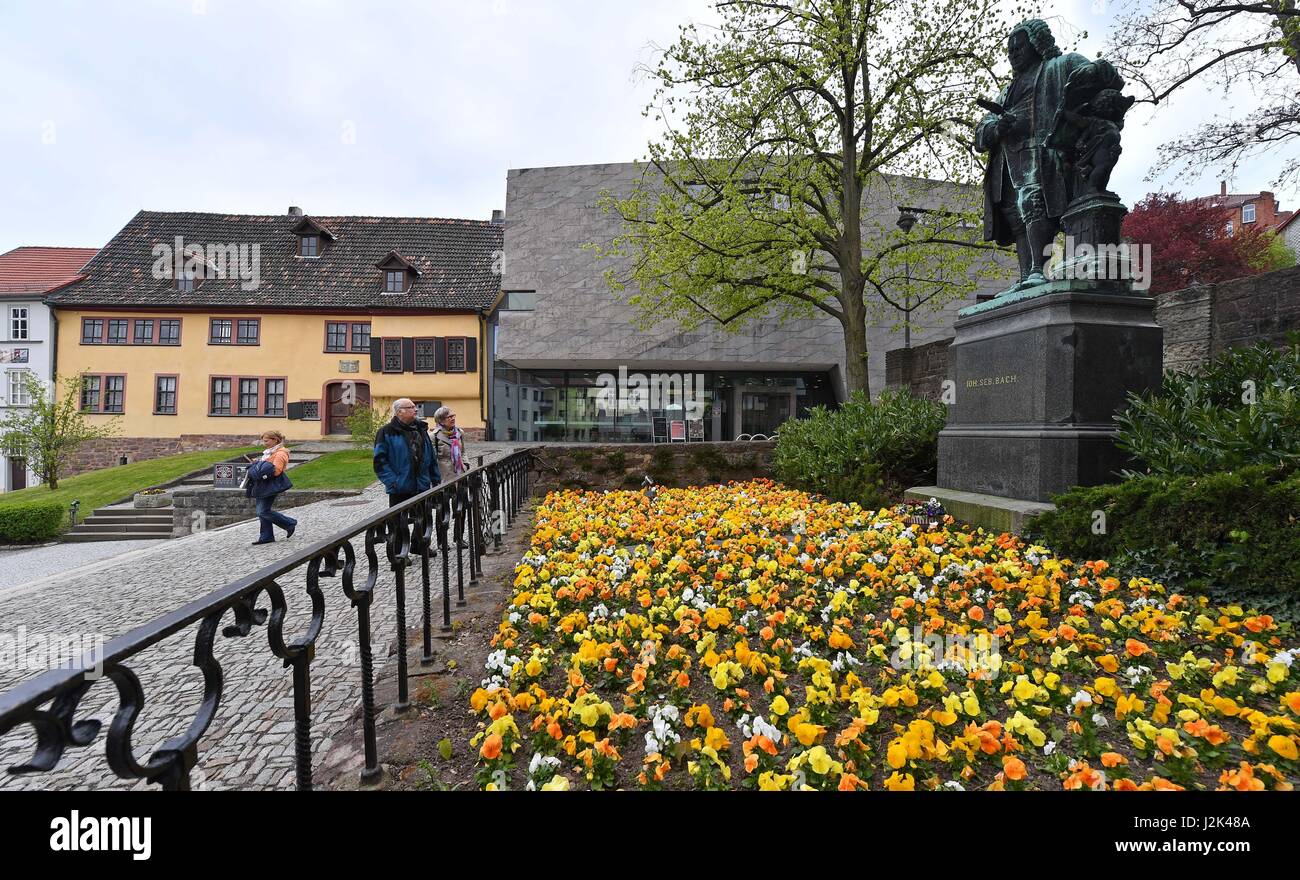 Visitors look at a statue of Bach in front of the Bachhaus, where the exhibition 'Text: Luther & Music: Bach' will open in Eisenach, Germany, 28 April 2017. Martin Luther (1483 - 1546) made music a trademark of the reformation, he wrote 37 church songs. At least 30 of those songs Bach (1685-1750) used for his oratorios, organ choirs, passions and cantata. The exhibition can be visited until the 28th of February 2018. Photo: Martin Schutt/dpa-Zentralbild/dpa Stock Photo