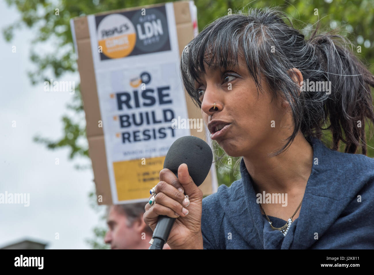 London, UK. 29th April 2017. Sheila Menon, Plane Stupid, speaks about the need to become active to oppose the governments envrionmentally disastrous polices - such as aviation expansion - at the Campaign against Climate Change rally to show solidarity with the People's Climate March in the US, and to tell Theresa May not to follow Trump down the path to climate disaster. After speeches opposite Parliament, people carried giant letters spelling out 'TRUMP & MAY CLIMATE DISASTER' and walked with them to Westminster Bridge for photographs. Unfortunately the letters proved difficult to see from th Stock Photo