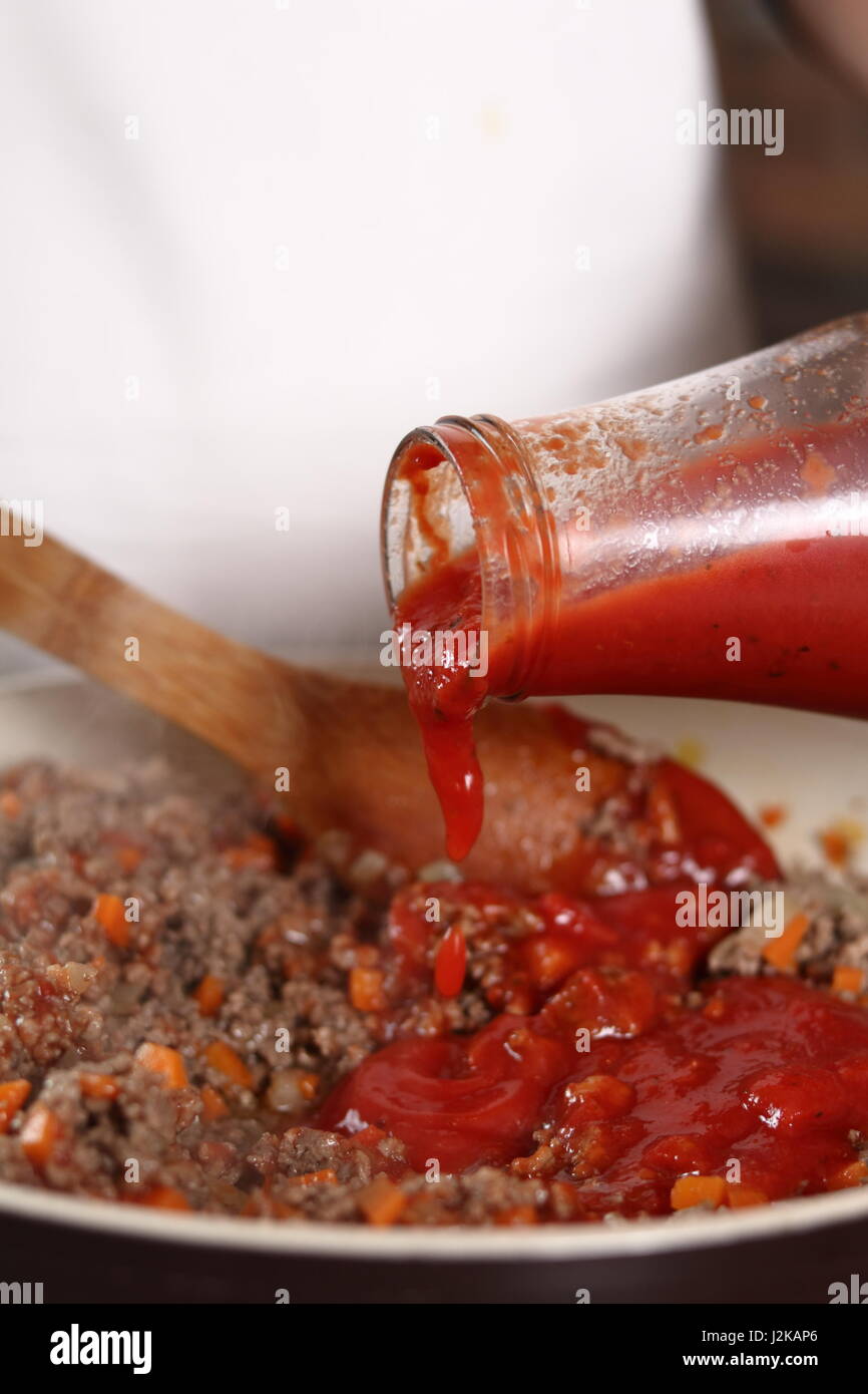 Adding tomato paste into ground meat. Making Lasagna Bolognese Series. Stock Photo