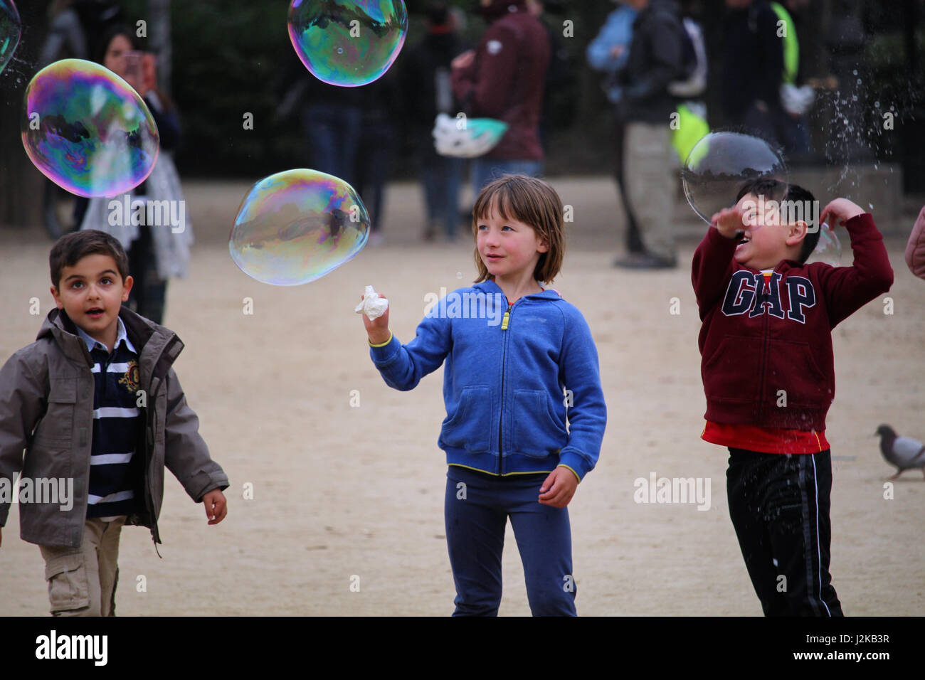 BARCELONA/SPAIN - 19 APRIL 2017: Childrean playing with big soap bubbles in Barcelona's Ciutadella park Stock Photo